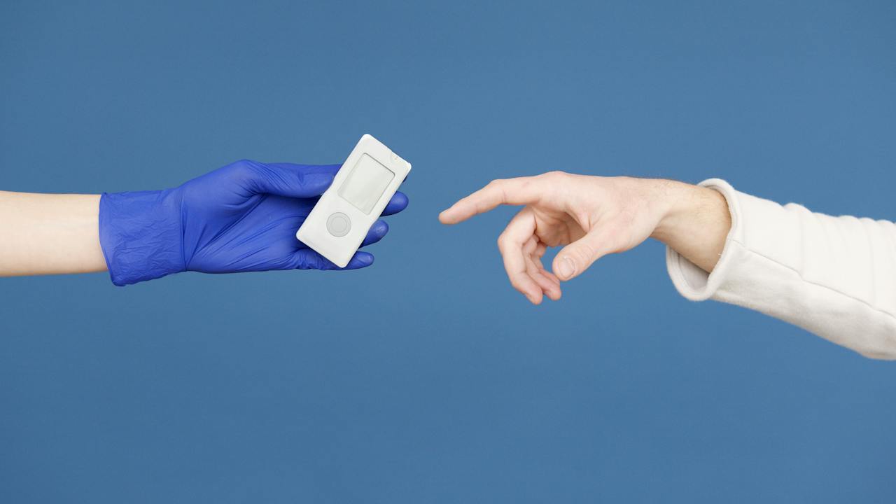 a hand pointing to a diabetes machine