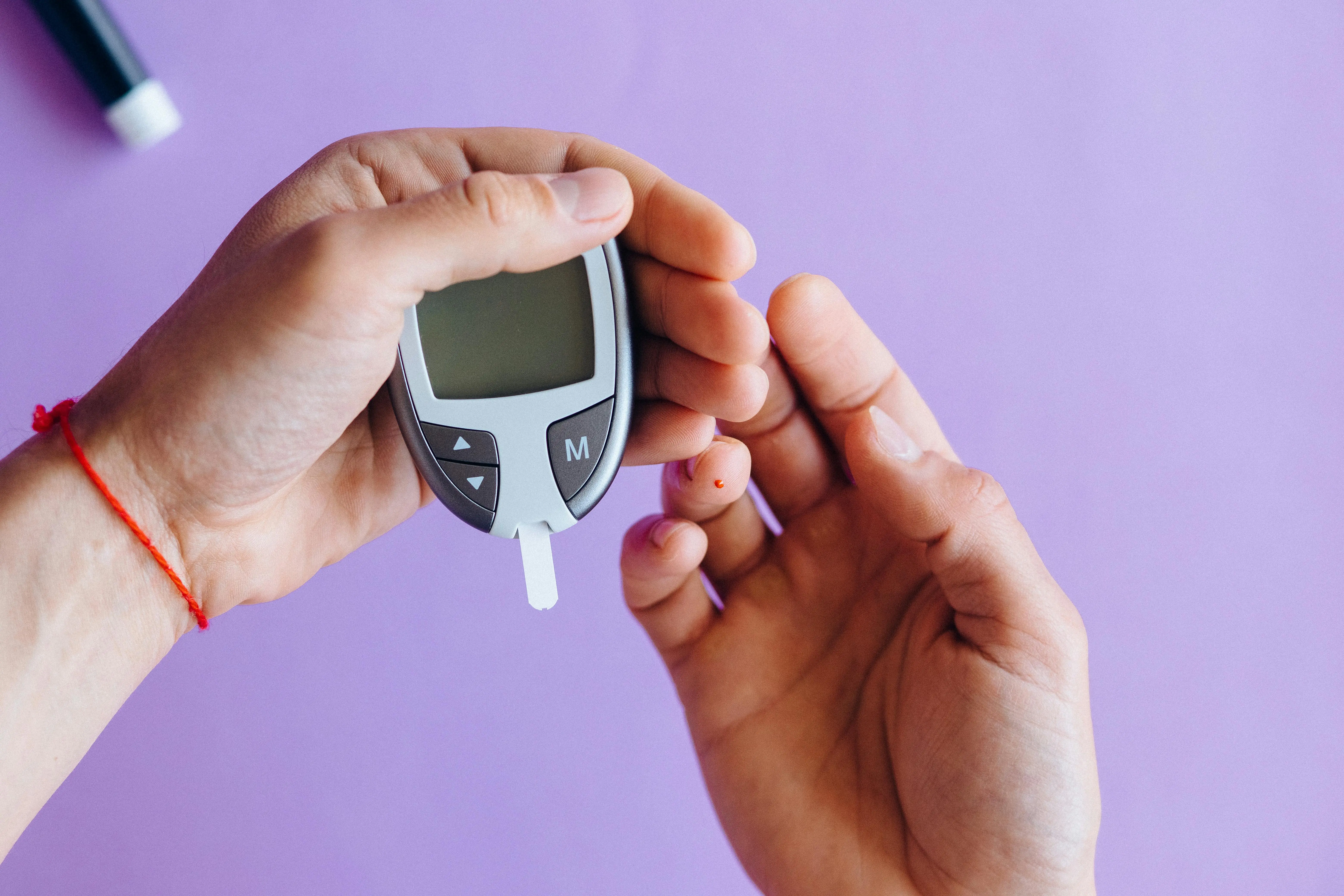 A close-up of a person checking blood sugar levels using a glucose meter as part of natural diabetes management strategies.