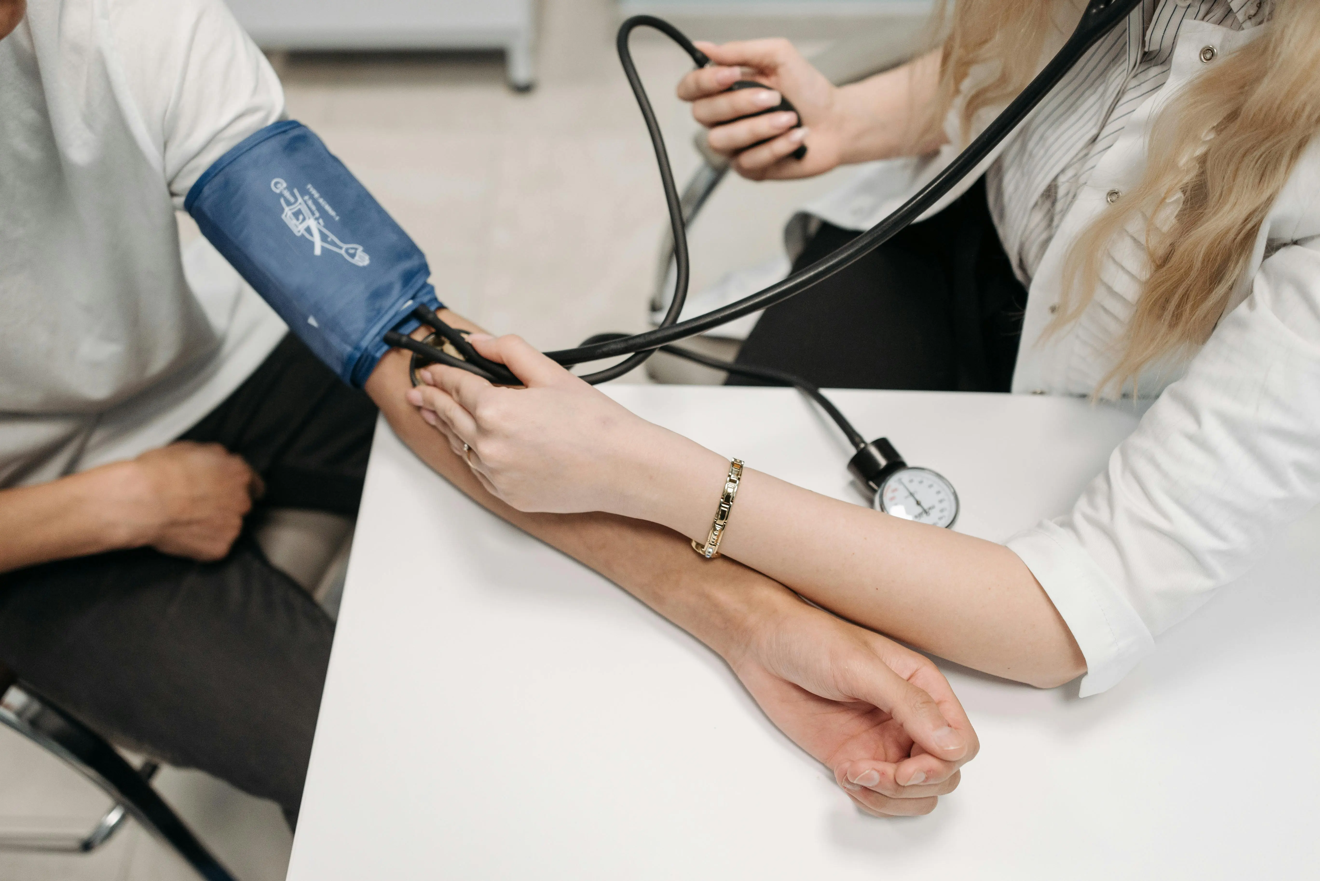 Doctor checking a patient’s blood pressure using a sphygmomanometer during a hypertension consultation.