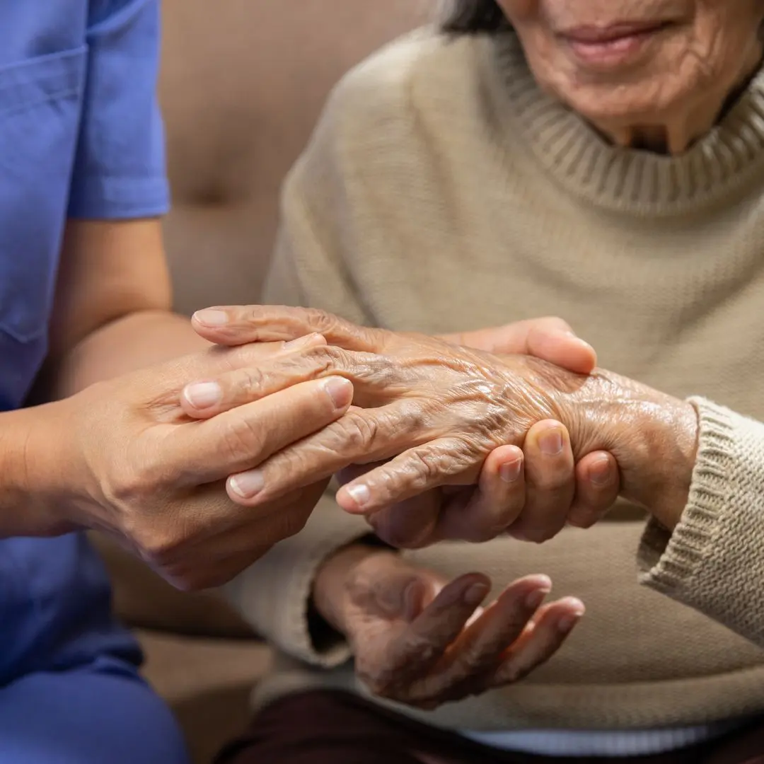 Healthcare professional holding the hands of an elderly patient with rheumatoid arthritis, symbolizing joint pain relief, care, and medical support for arthritis management.