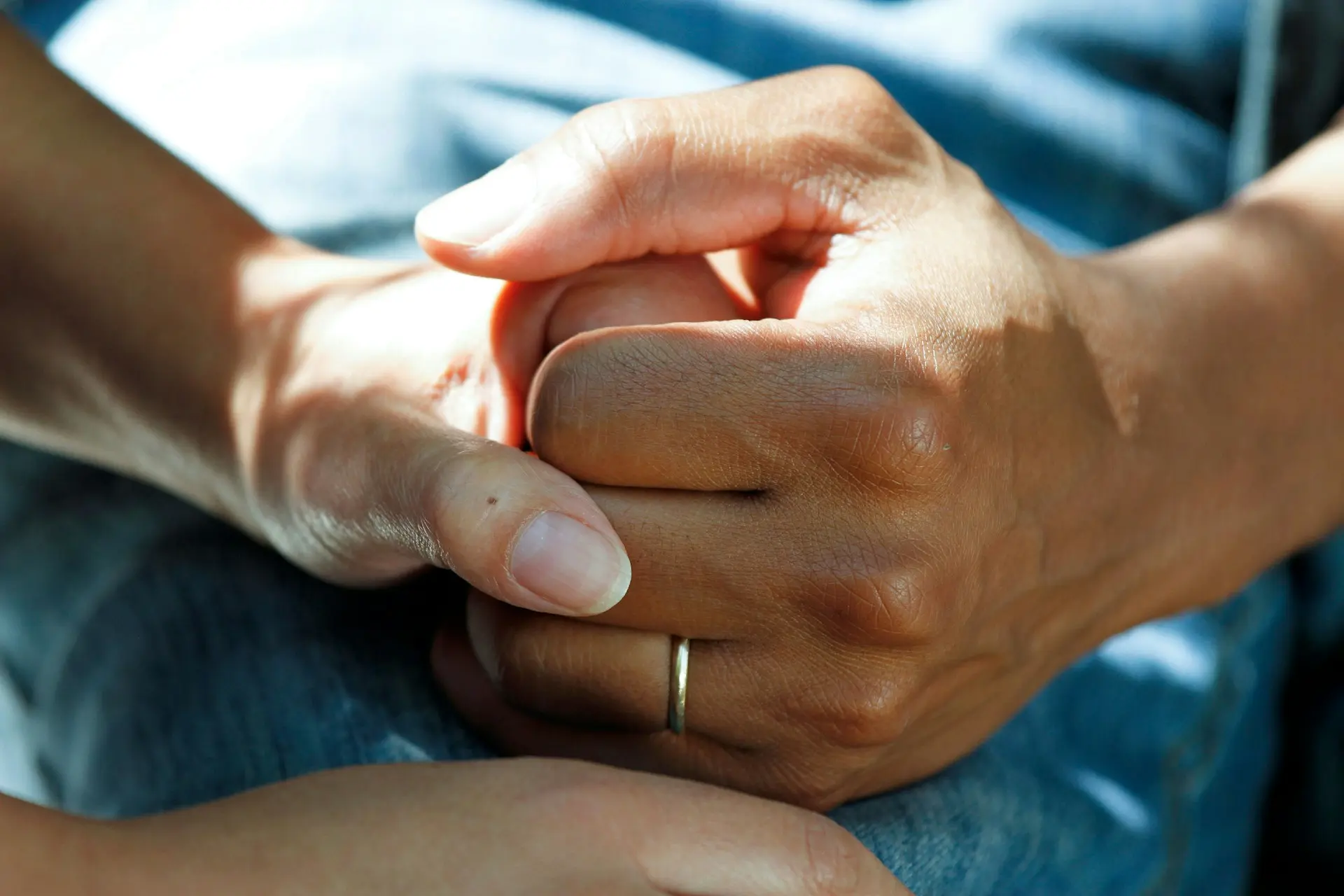 Close-up of hands holding for emotional support during cancer care, symbolizing compassion and strength in battling cancer.