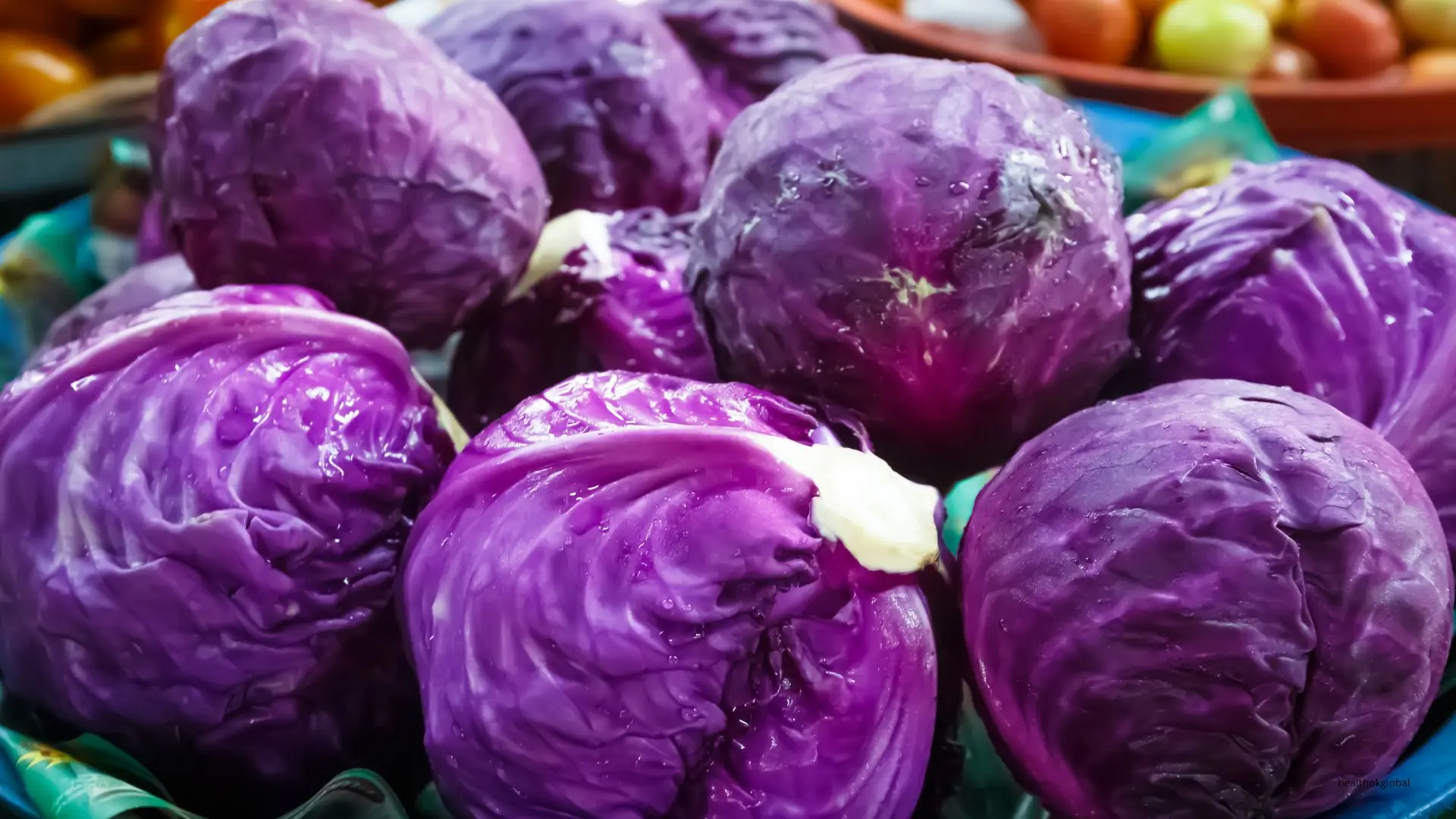 Fresh purple cabbage heads displayed at a market, highlighting their vibrant color and nutritional benefits as a healthy cruciferous vegetable.