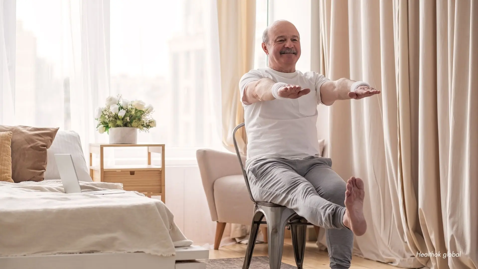 Senior man performing seated leg exercises at home, demonstrating low-impact chair exercises for seniors to improve strength, balance, and mobility.