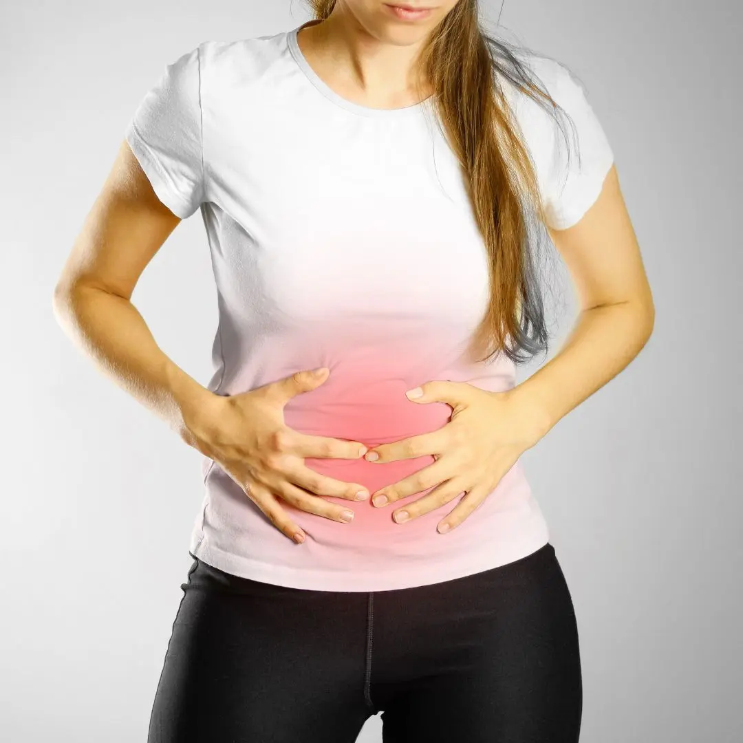 A woman holding her abdomen, indicating discomfort and symptoms of constipation. The image highlights abdominal pain associated with bowel irregularities.